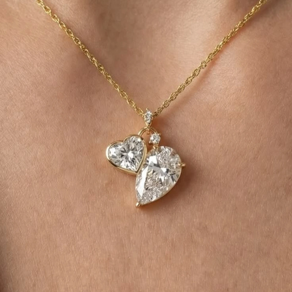 A heart and pear lab-grown diamond pendant on a fine yellow gold chain