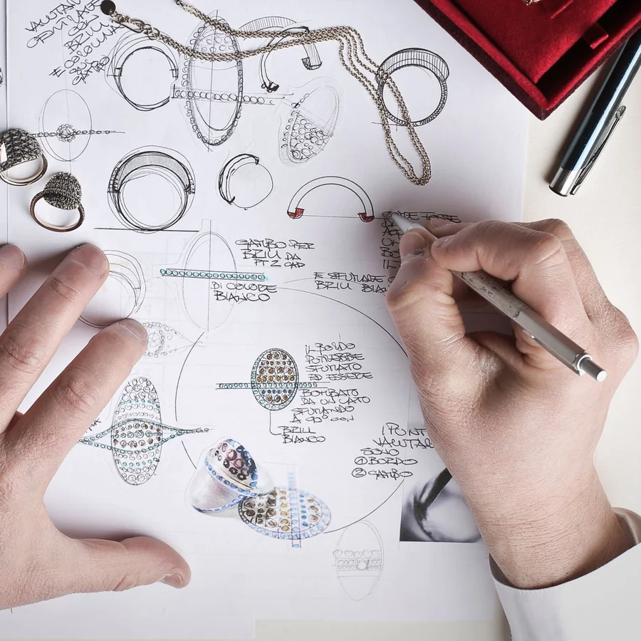 A jeweler sketching ring designs in pencil on paper